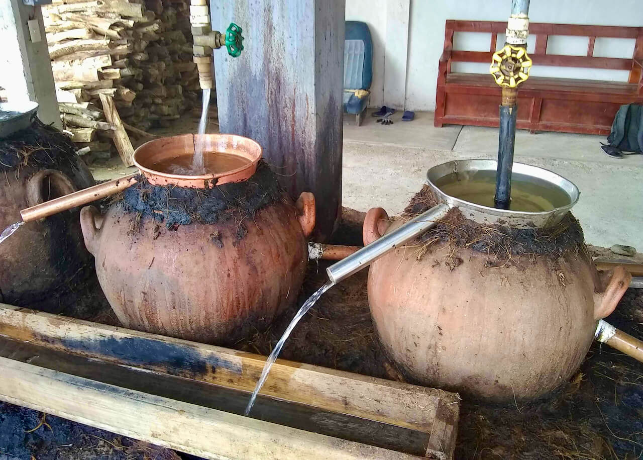 Two clay pot stills with copper and steel condensers using a water saving system