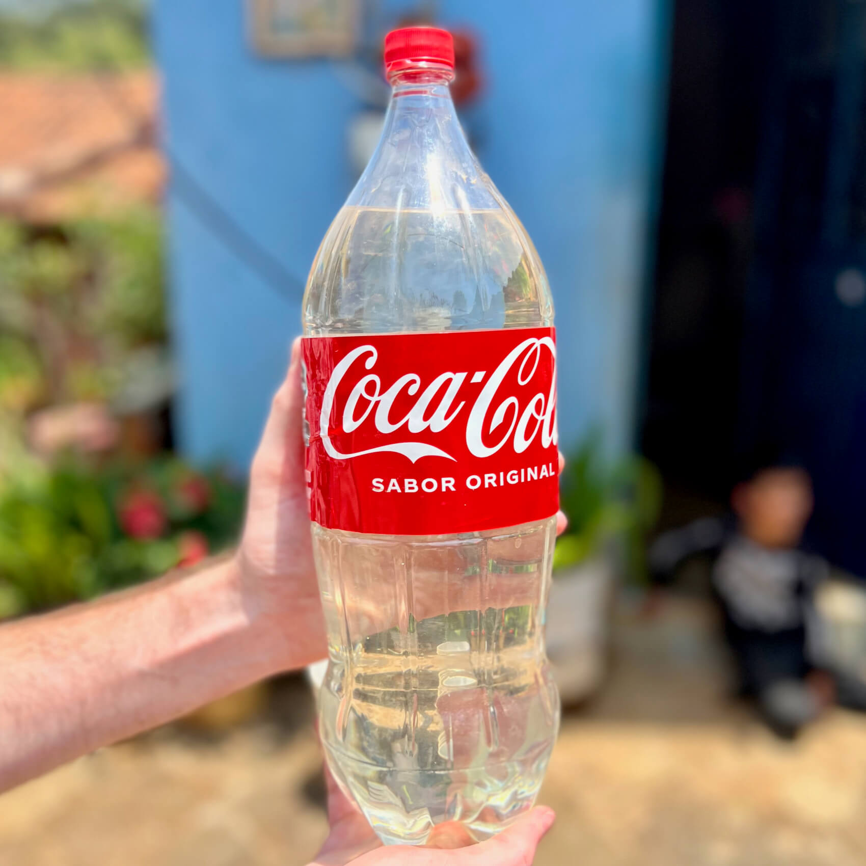 A two liter plastic Coca Cola bottle filled with raicilla